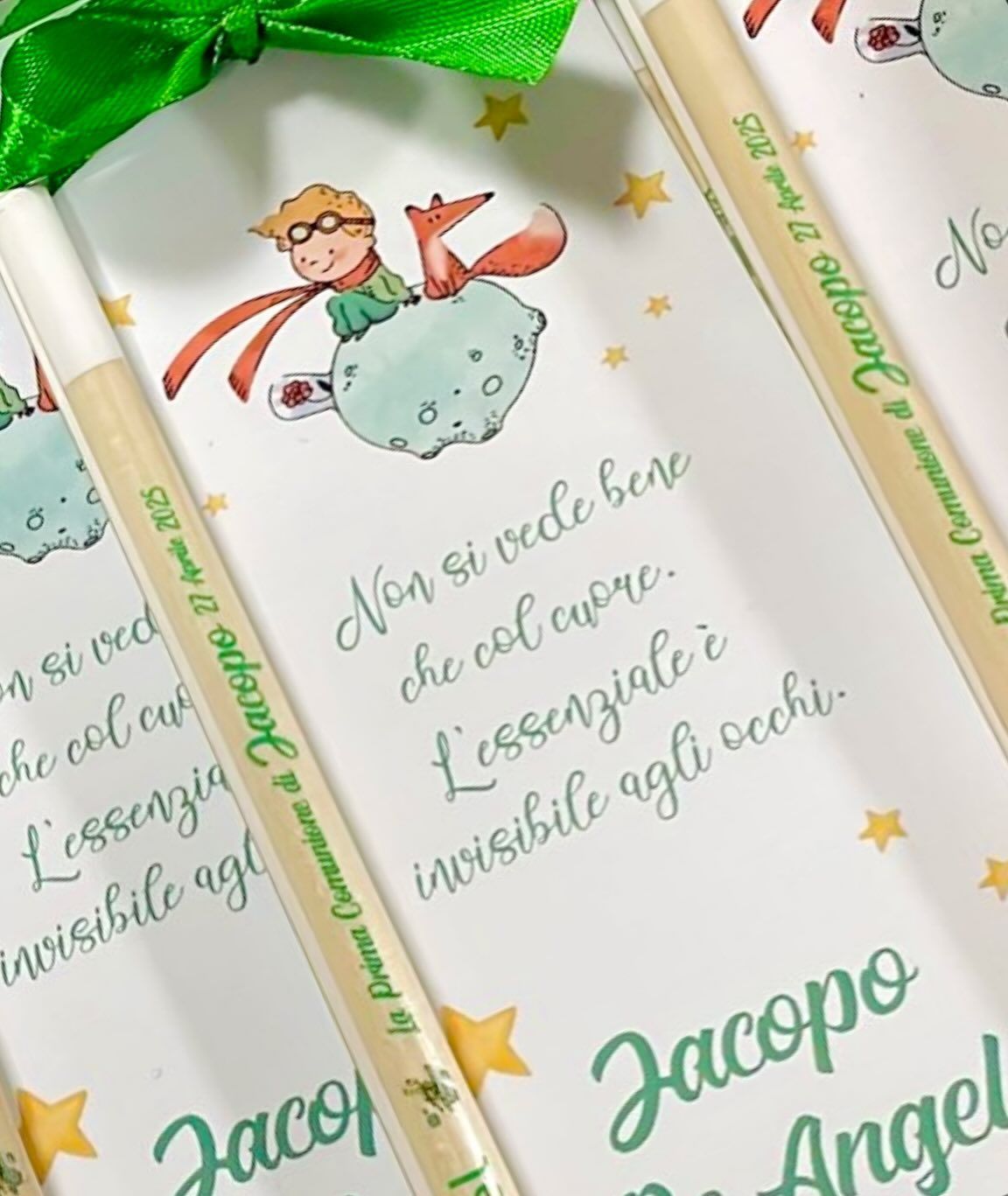Bomboniere con illustrazione e citazione del Piccolo Principe, matite con scritte e un nastro verde.