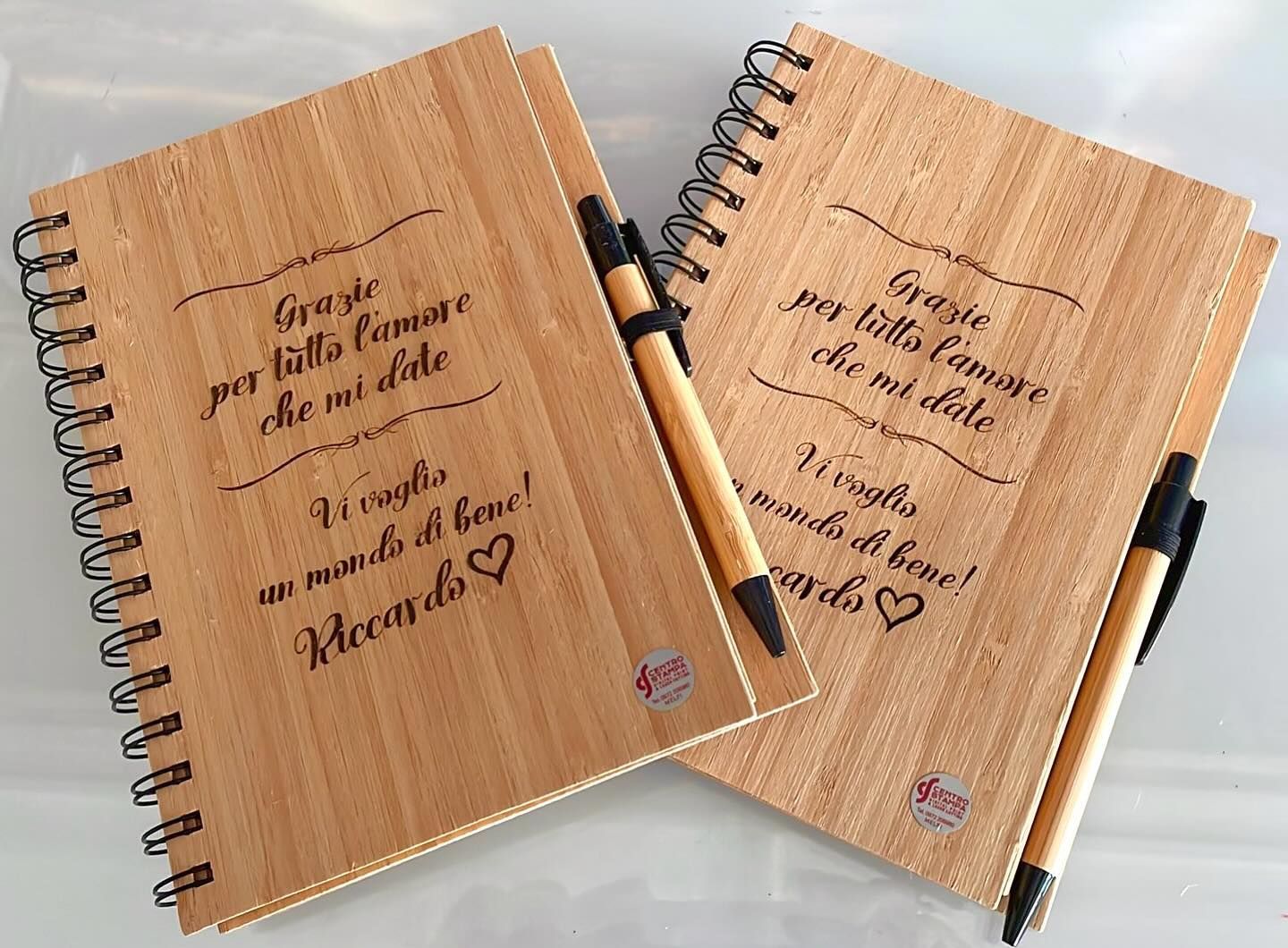 Due quaderni di legno con rilegatura a spirale, penne e scritta in italiano: