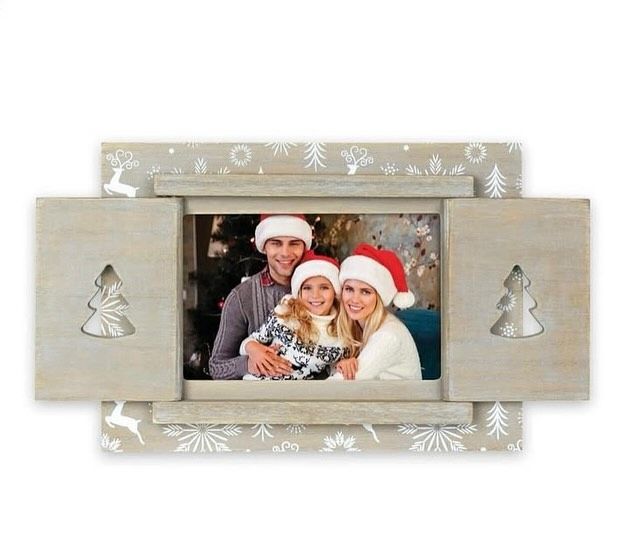 Cornice natalizia con famiglia con cappelli da Babbo Natale. Persiane in legno, fiocchi di neve e sagome di alberi.