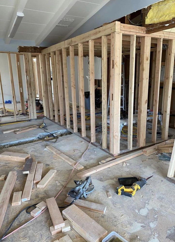 Interior of a building under construction, showing wooden wall framing on a concrete floor. Interior of a building under construction, showing wooden wall framing on a concrete floor.