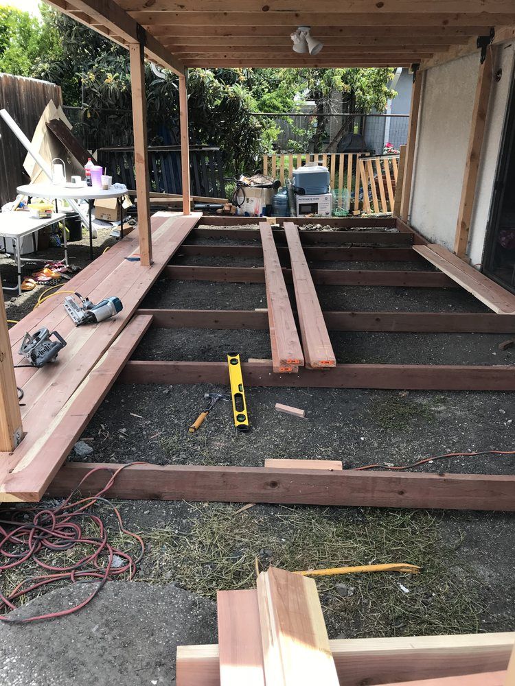 Person on ladder, working on the side of a house, bright blue sky in the background. Person on ladder, working on the side of a house, bright blue sky in the background.