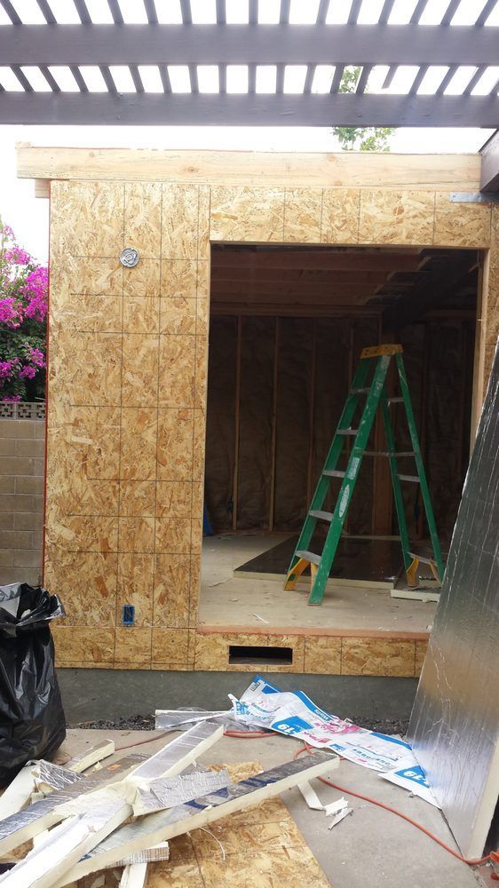 Construction site: exterior wall with open doorway, green lad der inside. Construction site: exterior wall with open doorway, green lad der inside.