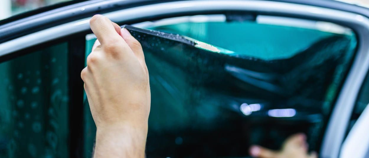 professional applying ceramic window tint on car glass