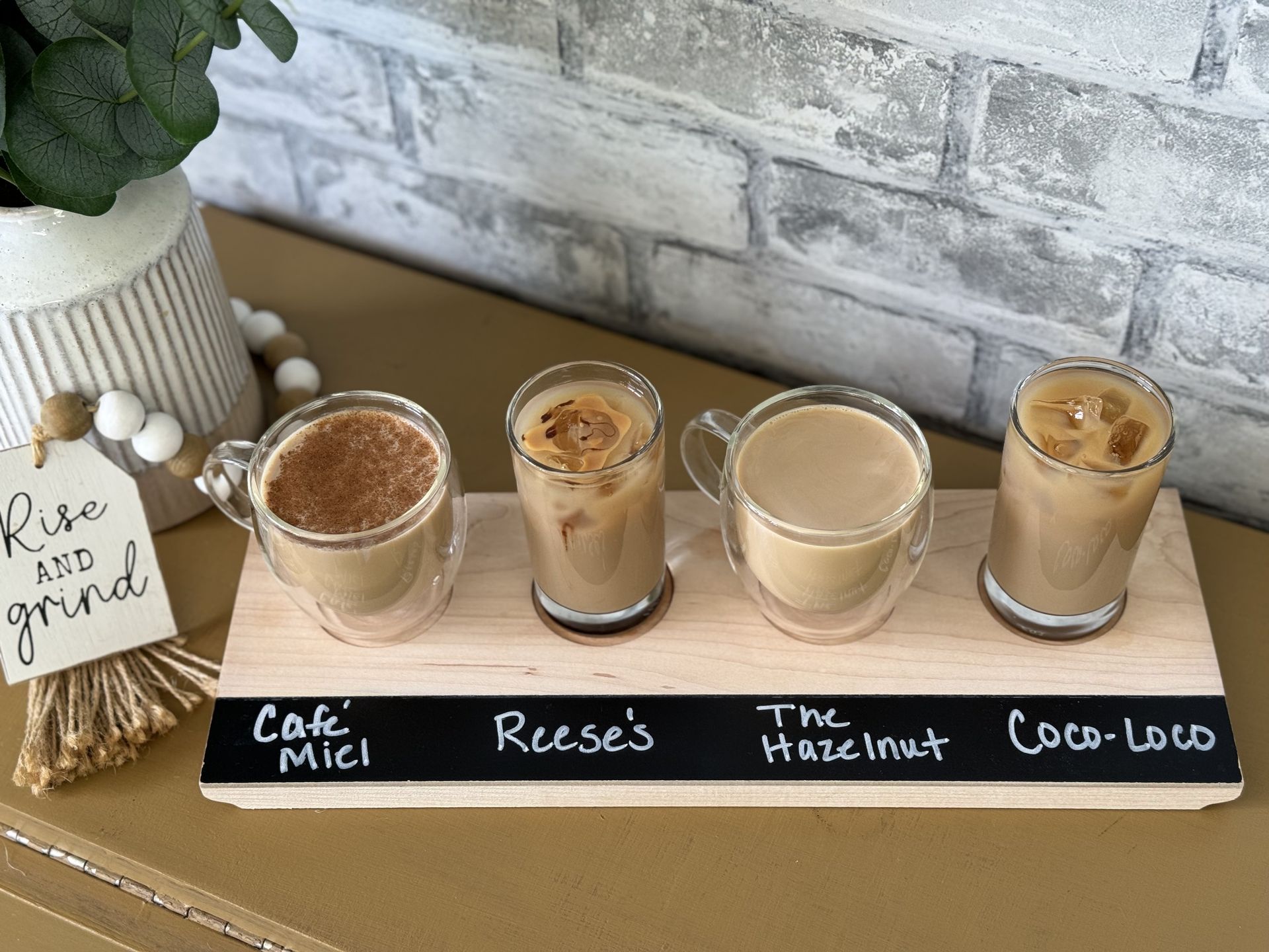 A wooden tray with four cups of coffee on it.