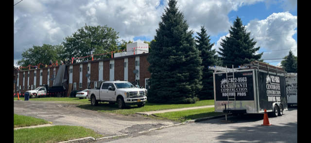 A white truck is parked in front of a building.