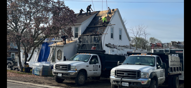A couple of trucks are parked in front of a house.