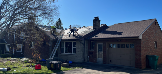 Residential roofing service - a man is working on the roof of a house.