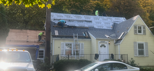 A car is parked in front of a house that is being remodeled.