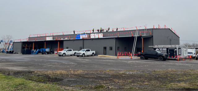 A large building with a lot of cars parked in front of it.