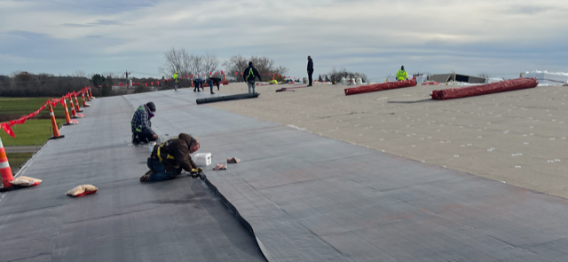 A group of people are working on a roof.