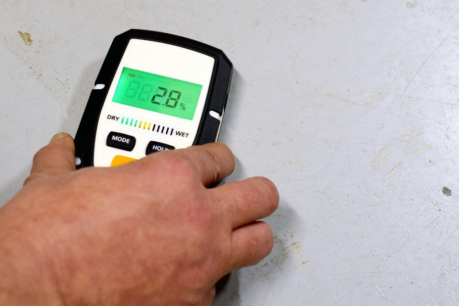 a handheld moisture meter showing 28% humidity in a miami-dade home