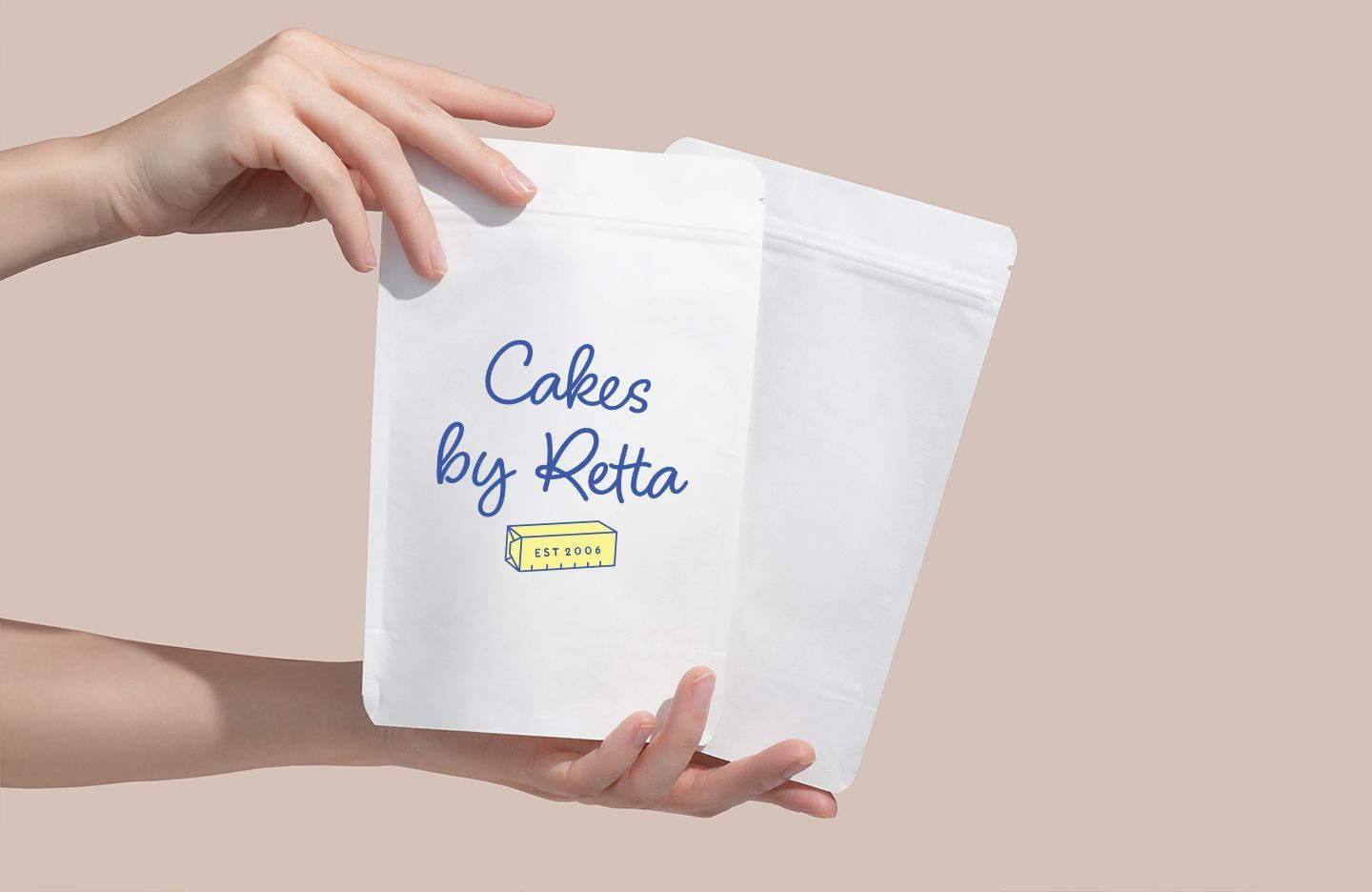 Hands holding two white food pouches, one labeled 