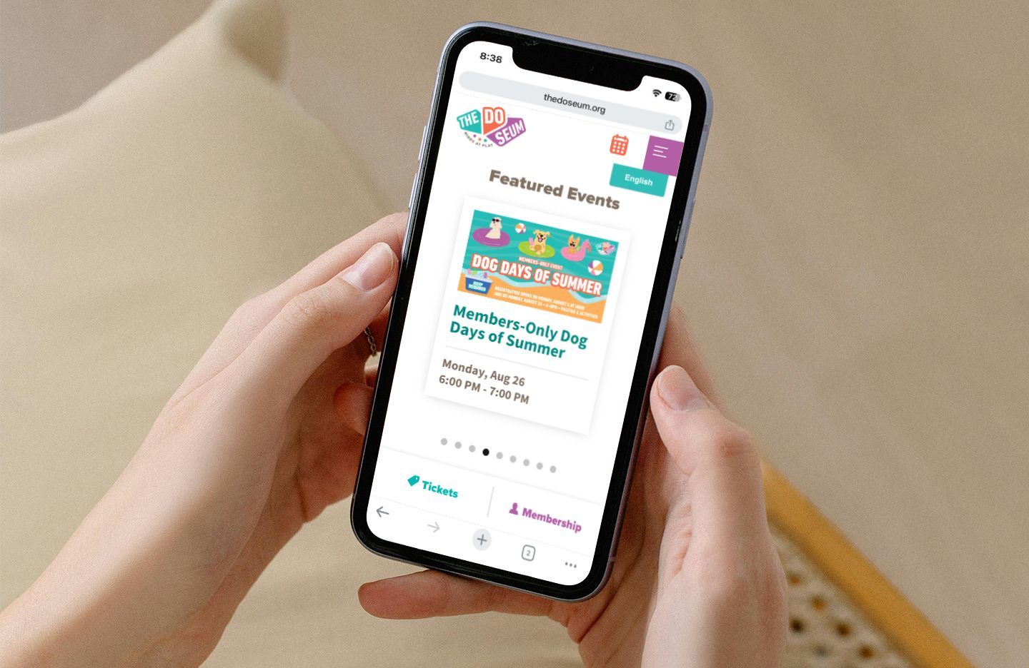 Person holding a phone displaying a webpage for a summer event.