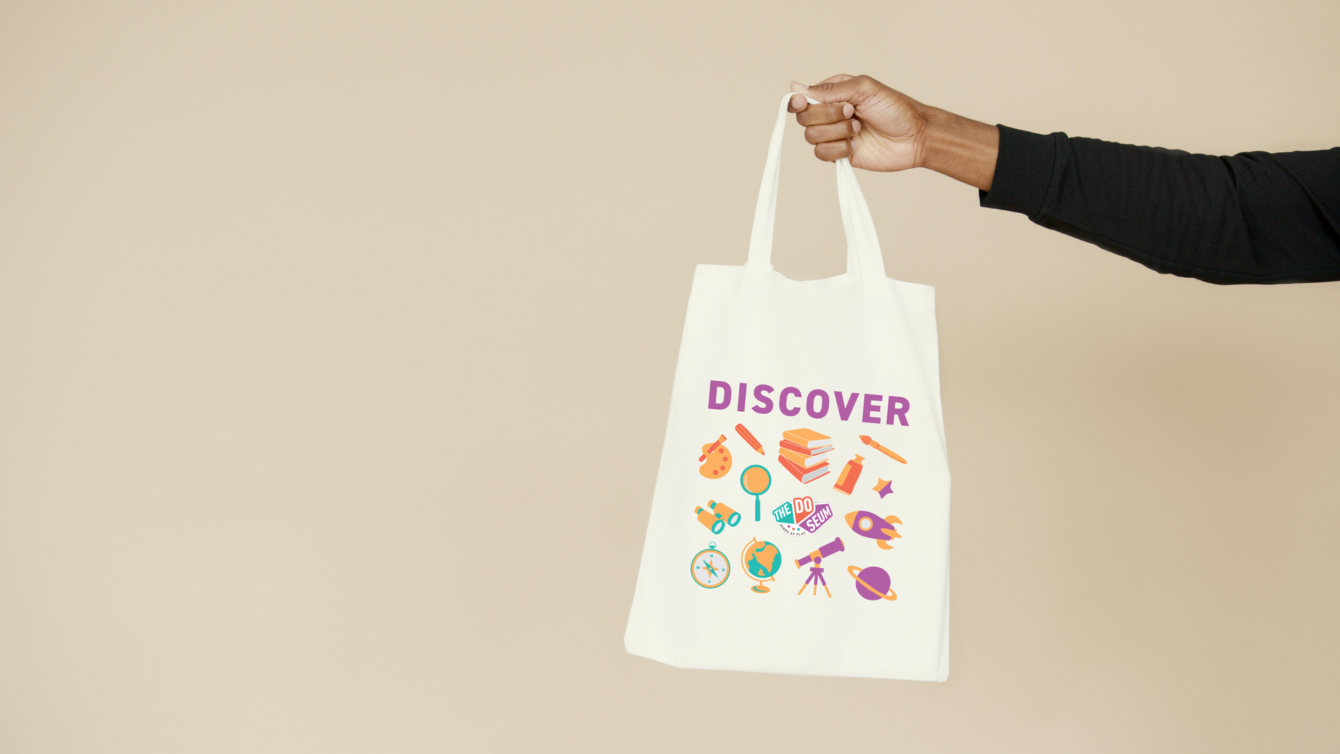 Hand holding a white tote bag with