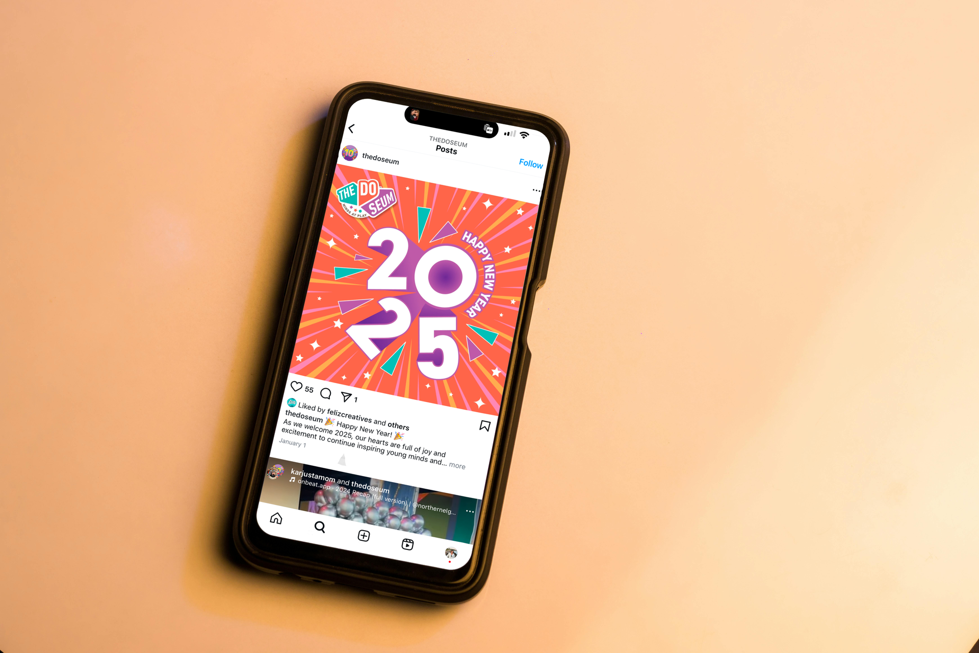 Smartphone on a peach surface displays a social media post with