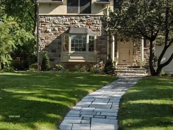 Un passage en pierre mène à une maison en pierre