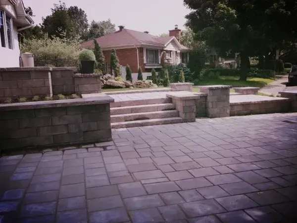 Un patio en brique avec des escaliers menant à une maison