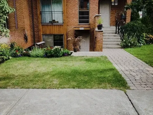 Une maison en brique avec une pelouse verte luxuriante devant elle