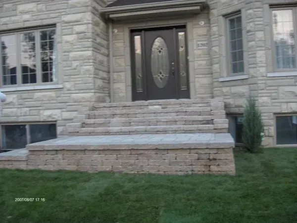 Une maison en brique avec des escaliers menant à la porte d'entrée