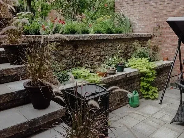 Un patio avec un mur de briques et des plantes en pot
