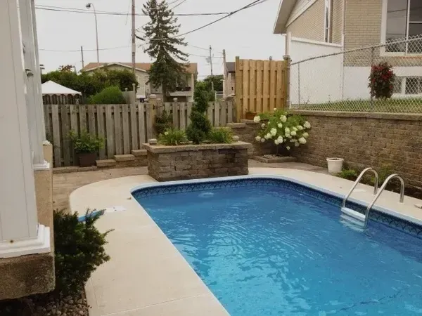 Une grande piscine dans une cour à côté d'une maison
