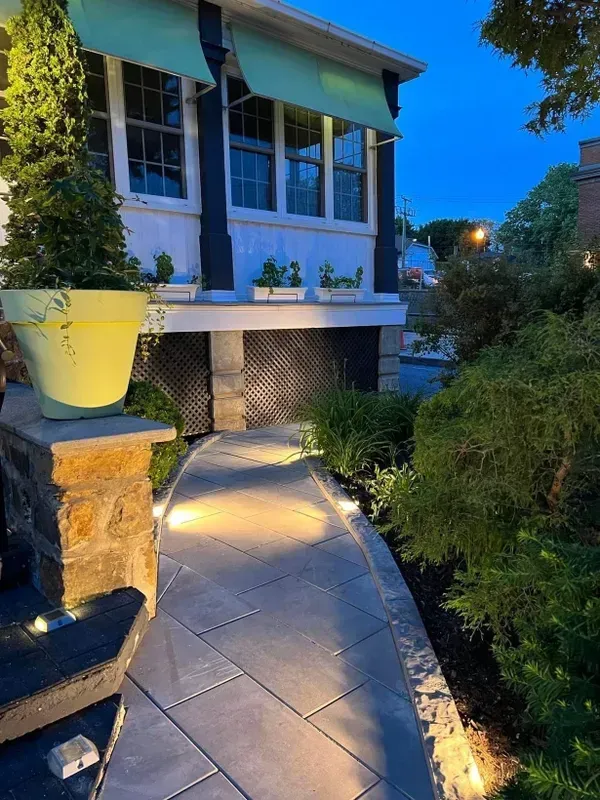 Une passerelle menant à une maison avec des plantes en pot sur le côté.