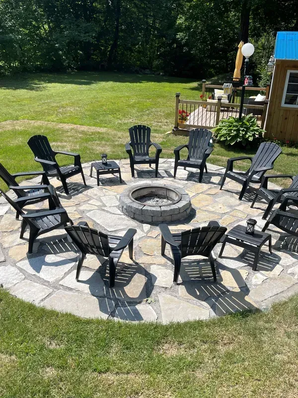 Un foyer entouré de chaises et de tables dans une cour.