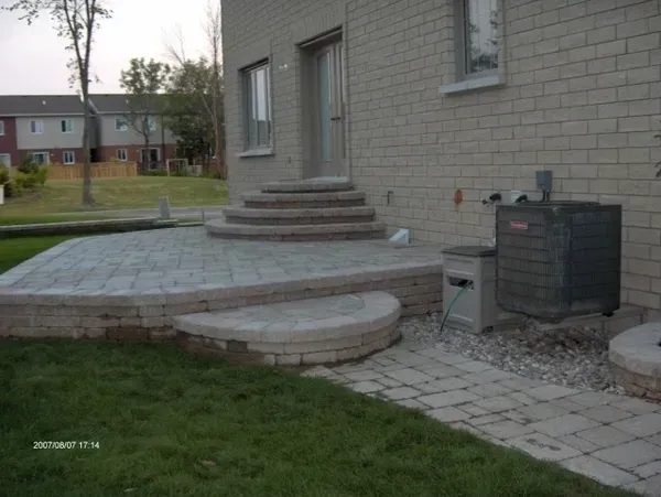 Une maison en brique avec un patio et des escaliers devant