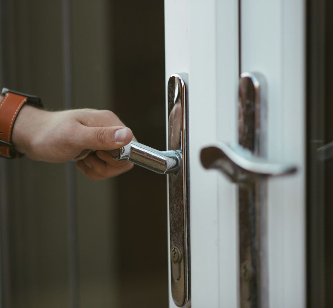 A person is opening a door with a door handle.