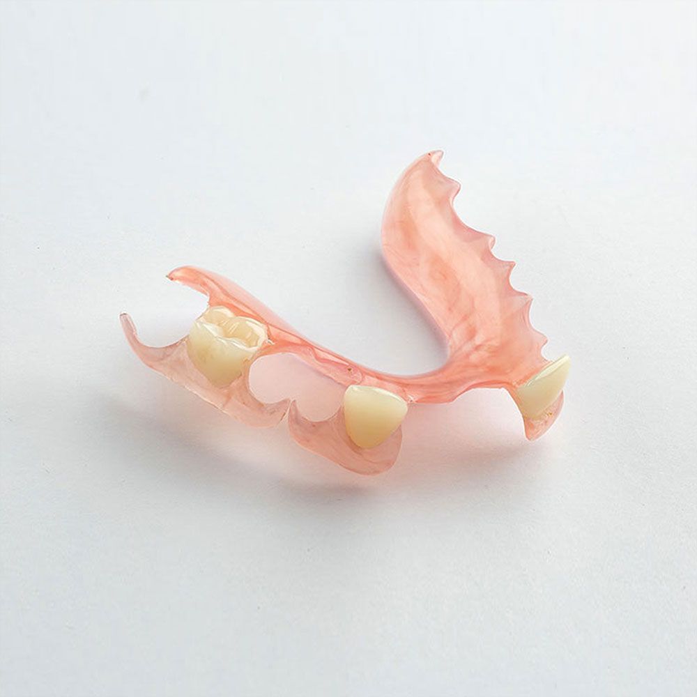 Close-up of teeth decorated with sparkly gems, with full pink lips visible.