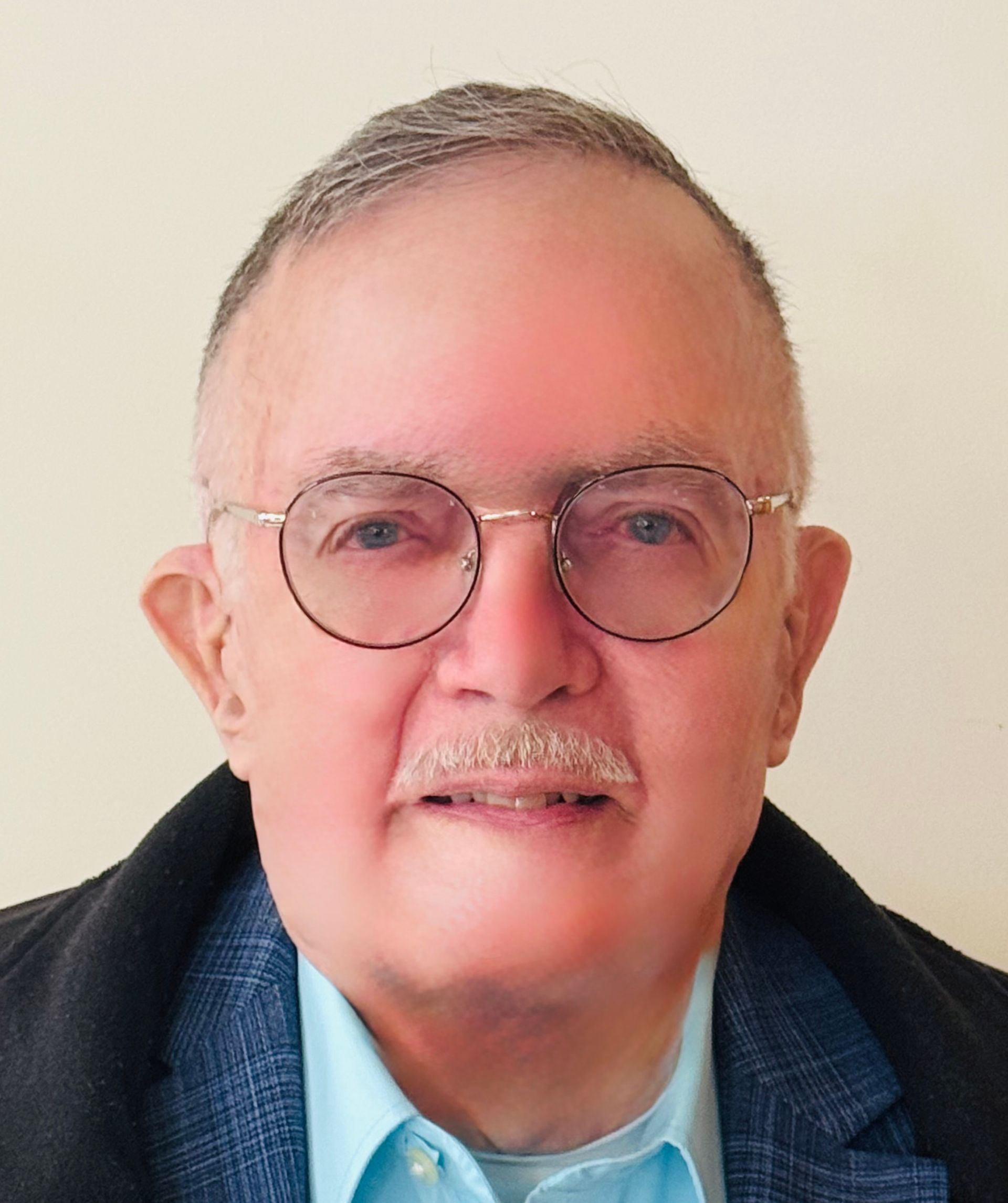 A man with glasses and a mustache is smiling for the camera.