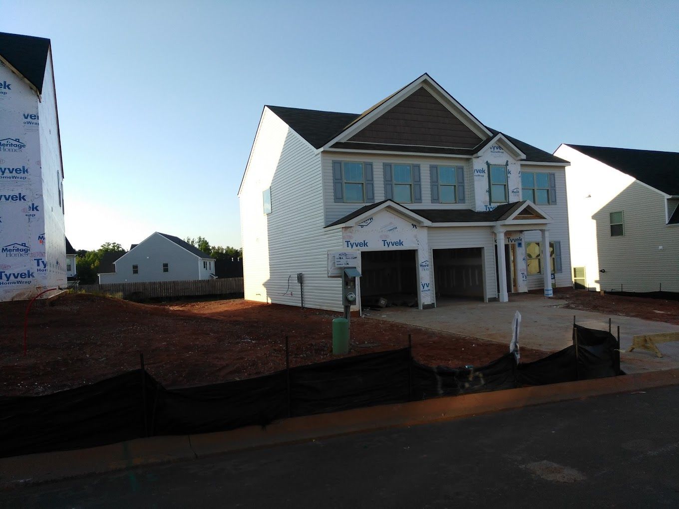 A white house with a brown roof is under construction