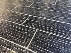 Close-up of a black and white textured floor resembling wood planks.