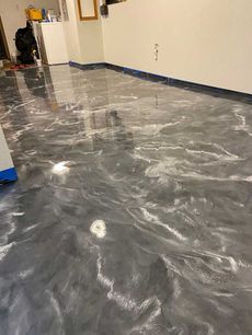 Metallic gray and white epoxy floor with swirling patterns in a room.