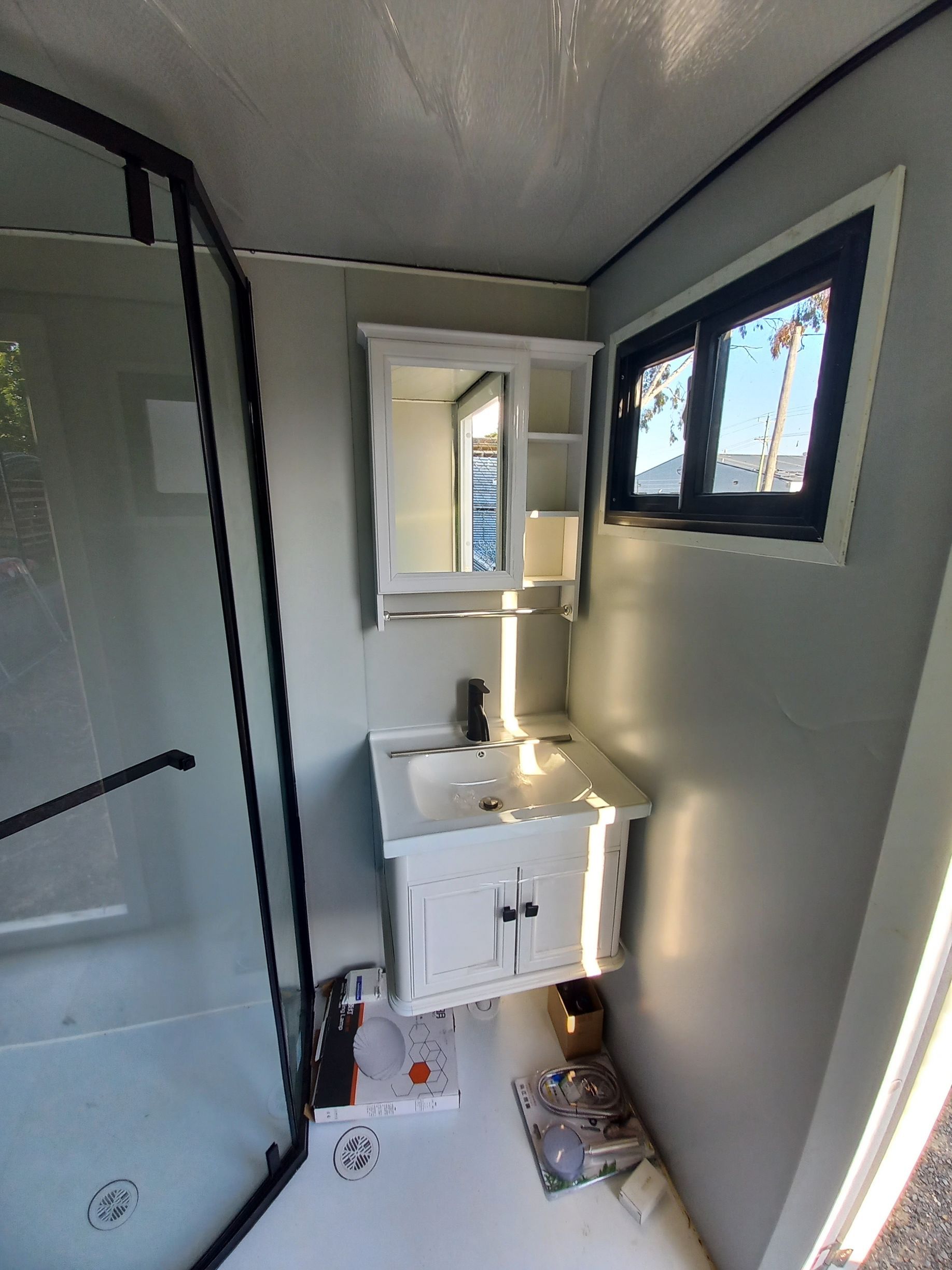Small bathroom with white vanity, medicine cabinet, shower, and small window — Tenterfield Timber & Hardware in Tenterfield, NSW