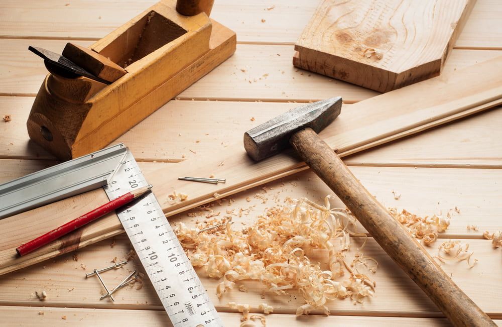 A Wooden Table With A Hammer , Plane , Ruler , Pencil And Wood Shavings  — Tenterfield Timber & Hardware in Tenterfield, NSW