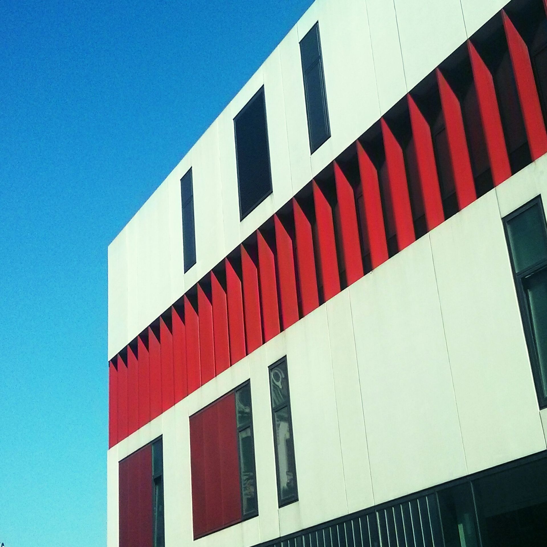 A red and white building with a blue sky in the background