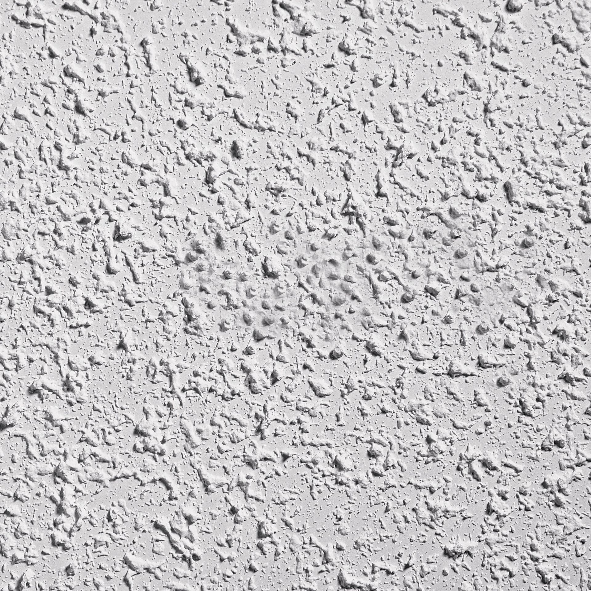 A close up of a white wall with a gray texture.