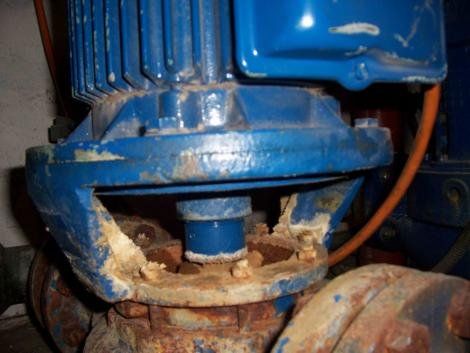 Blauer Elektromotor an einer rostigen, korrodierten Pumpe; Aufnahmeort: Innenbereich.