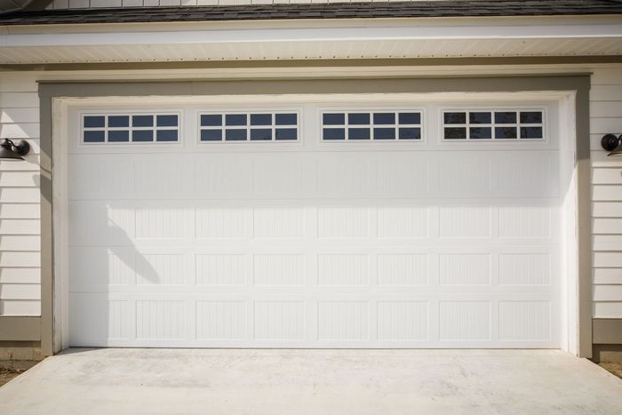 A white garage door with a lot of windows on it