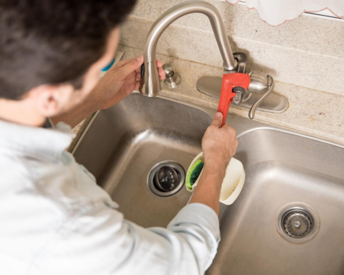 Cuatro obreros de la construcción en un tejado, trabajando en un edificio. Uno en una escalera, los demás con herramientas.