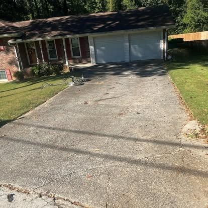 A concrete driveway leading to a house with a garage.