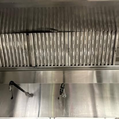 A stainless steel hood with tongs attached to it.