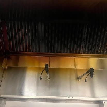A close up of a stainless steel exhaust hood in a kitchen.