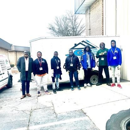 A group of men standing in front of a white van