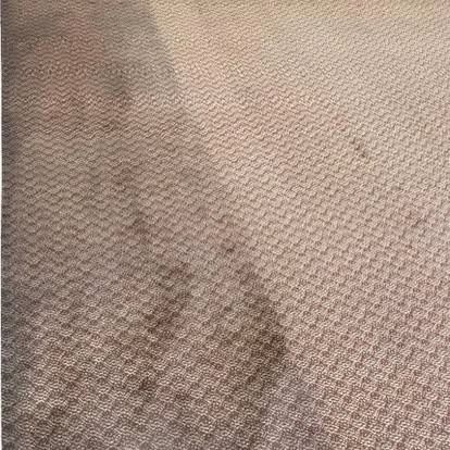 A close up of a carpet with stains on it.
