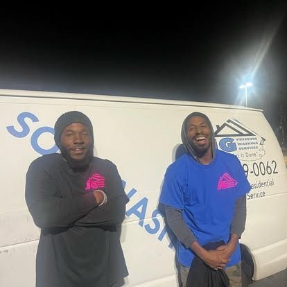 Two men are standing next to each other in front of a white van.
