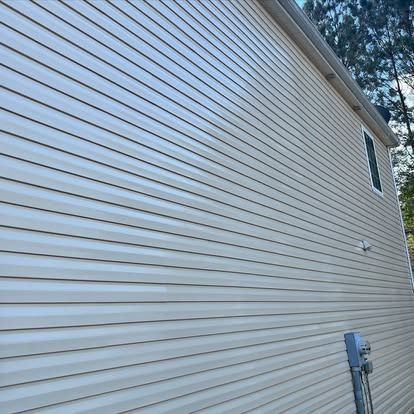 The side of a house with white siding and a window.