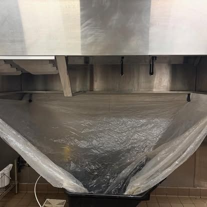 A plastic bag is hanging from the ceiling of a kitchen sink.