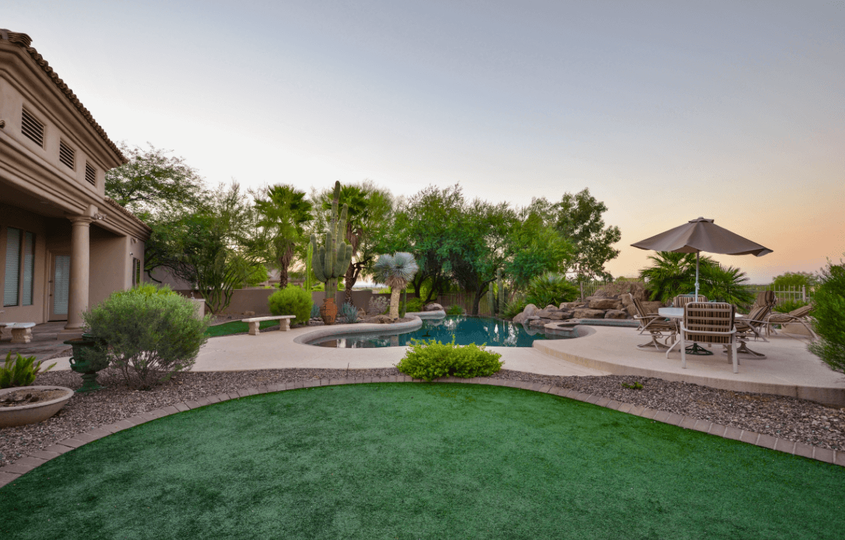 A picture of a backyard with artificial turf and drip irrigation